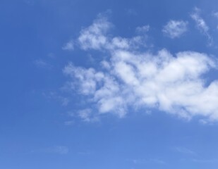 Fototapeta premium Fluffy clouds drifting across blue sky