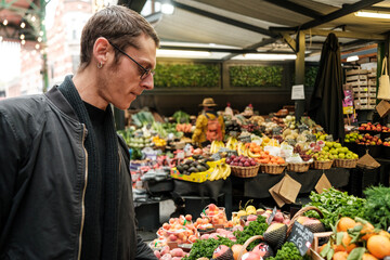 Man choosing fresh fruits and vegetables at a market stall