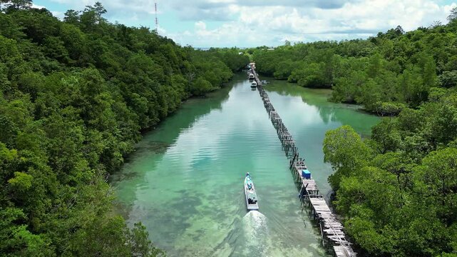 Maratua, Indonesia: Aerial drone footage of a boat delivering supplies to various village and resort in the stunning Maratua lagoon and island in the Derawan archipelago in Indonesia. 
