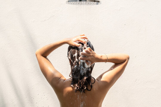 Beautiful woman's hand She was washing her hair and nourishing her scalp. Shampoo and conditioner	