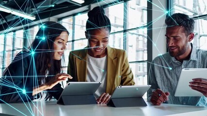 High-angle video of three people using tablets, overlaid with digital network lines, symbolizing teamwork and technology in a modern office. - Powered by Adobe