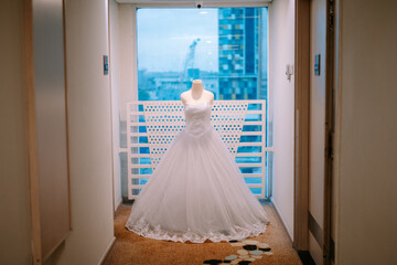 Elegant wedding dress on mannequin, luminous urban backdrop indoors