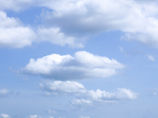 Fototapeta premium Bright blue sky with soft, scattered white clouds on a sunny day