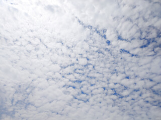 Bright blue sky with soft, scattered white clouds on a sunny day