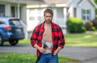 Handsome man with axe. Lumberjack at his house with ax. Lumberjack sweating hold heavy axe. Strong...