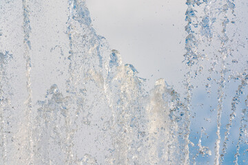 Splashes and jets of water against light background.