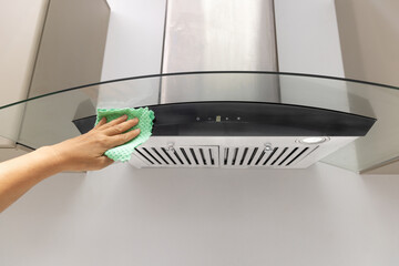 Hand cleaning kitchen hood with green microfibercloth