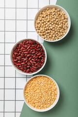 Beans in bowls on light background, top view