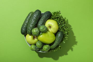 Set of protein vegetables in bowl on green background, top view