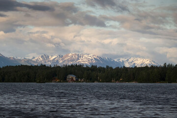 Sun shining on mountains behind lake in Wasilla