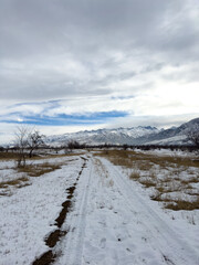 Snow covered mountains in Kyrgyzstan under cloudy winter sky peaceful rural landscape