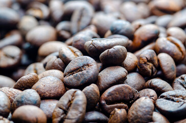 Close up view roasted coffee beans that highlights the texture and surface details of the coffee beans with customizable space for text