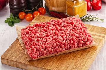 Raw minced beef meat over board