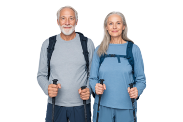 Active senior couple dressed in hiking gear, smiling and standing with trekking poles and backpacks, isolated on transparent PNG