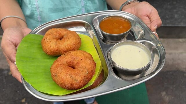 Masala Vada, a popular street food of South Indian cuisine served with chutney and sambhar. 