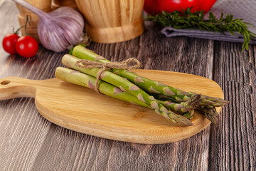 Raw green asparagus over board