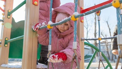 Girl playing on the playground on a cold winter day