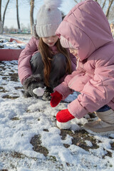 Two little girls playing on the playground on a winter day