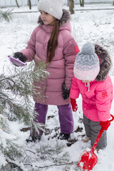 Active recreation with children in winter on cold days. Happy siblings having fun with snow