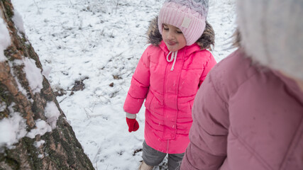 Active recreation with children in winter on cold days. Happy siblings having fun with snow