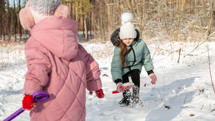 Playful family enjoying snowball fight in snowy winter park