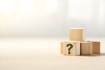 Obraz premium Contemplative wooden cubes arranged, bearing a prominent question mark, inviting inquiry