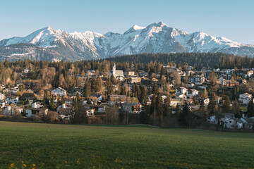 Mountain village surrounded by majestic snow-capped peaks and lush green fields