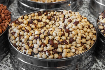 Roasted hazelnuts in metal container, close-up at market