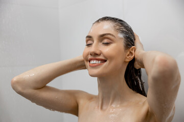 Brown haired woman bathing in shower with gel in bathroom washing hair relaxing at home