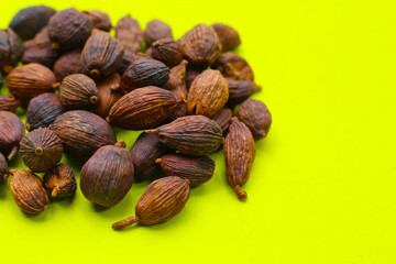 Black Cardamom on green background.