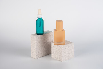 Blue serum bottle and cream sunscreen bottle with white background props