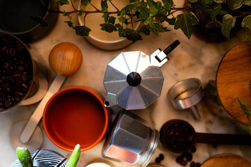 Ingredients for making coffee. Moka coffee maker, coffee grinder with coffee beans are on the table...