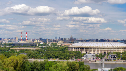 Breathtaking view of Moscow skyline from Vorobyovy Gory, with Moscow River, green trees, and clouds in the blue sky