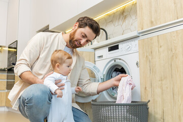 Young man and his little son sorting clothes before putting into washing machine