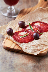 Sliced chorizo with fresh rosemary on rustic background. Copy space.	