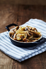 Onion with mushrooms. Rustic wooden background.	