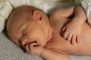 Newborn baby sleeping peacefully close to a warm blanket in a cozy indoor setting during daytime
