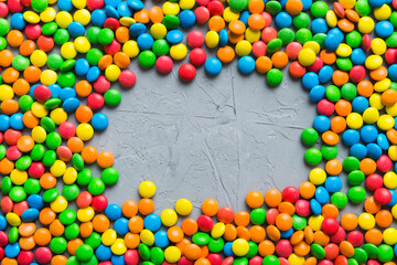 Mixed collection of colorful candy, on colored background. Flat lay, top view. frame of colorful chocolate coated candy