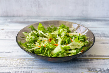 Fresh green microgreen salad on a light blue plate. A natural and organic concept for healthy eating and spring or summer food presentations.