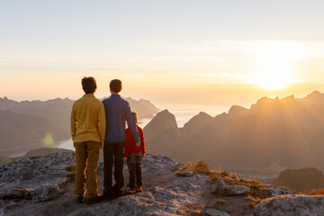 Fototapeta premium Children and adults, family with dog, hiking Grytetippen trail in Senja, Lofoten on a sunny hot summer day