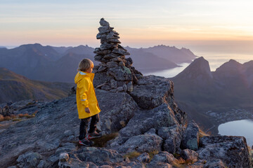 Children and adults, family with dog, hiking Grytetippen trail in Senja, Lofoten on a sunny hot summer day