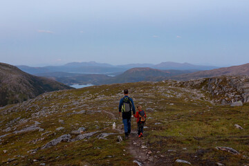Fototapeta premium Children and adults, family with dog, hiking Grytetippen trail in Senja, Lofoten on a sunny hot summer day