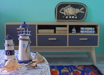 Lighthouses and shells on a table in a room decorated in a nautical style