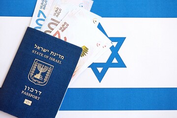 Israel New Shekels banknotes and passport on flag. The current Israel money bills and pass