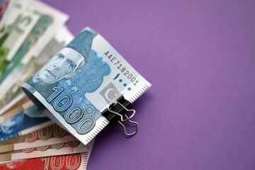 Pakistan rupees banknotes on purple background. The current Pakistan money bills