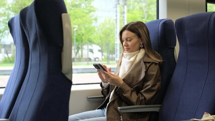 Girl Using Her Phone While Sitting on Public Transport in a Comfortable Setting During the Day