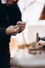 Close-Up of Artisan Sharpening Tool on Grinding Machine Outdoors