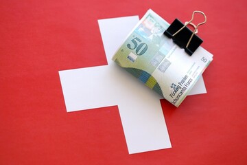 Swiss franc banknotes and flag. The francs money bills lies on flag in big amount