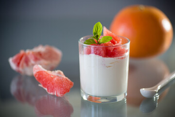 Light breakfast: yogurt and fresh grapefruit in a glass bowl