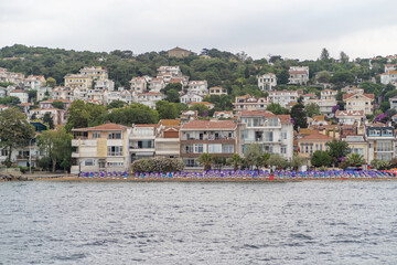 Beautiful coastal view of Prince Islands showcasing homes and beach umbrellas on a cloudy day with...